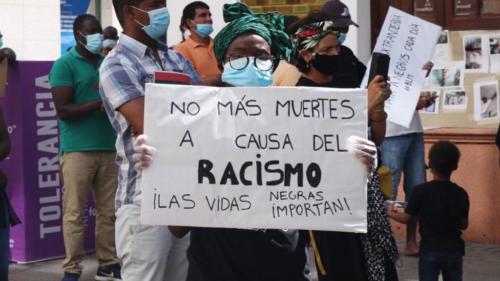 Una persona muestra una pancarta durante una concentración contra el racismo y la deportación de inmigrantes. Autora: Natalia G. Vargas, 20/11/2020. Fuente: elDiario.es (CC BY-NC-ND)