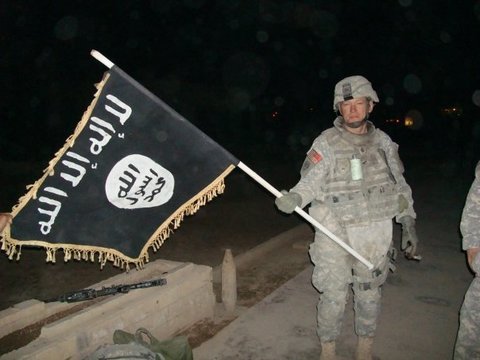 Soldado del ejército estadounidense sostiene una bandera del DAESH, el grupo que reivindica el asesinato de Malala Maiwand, en 2010.